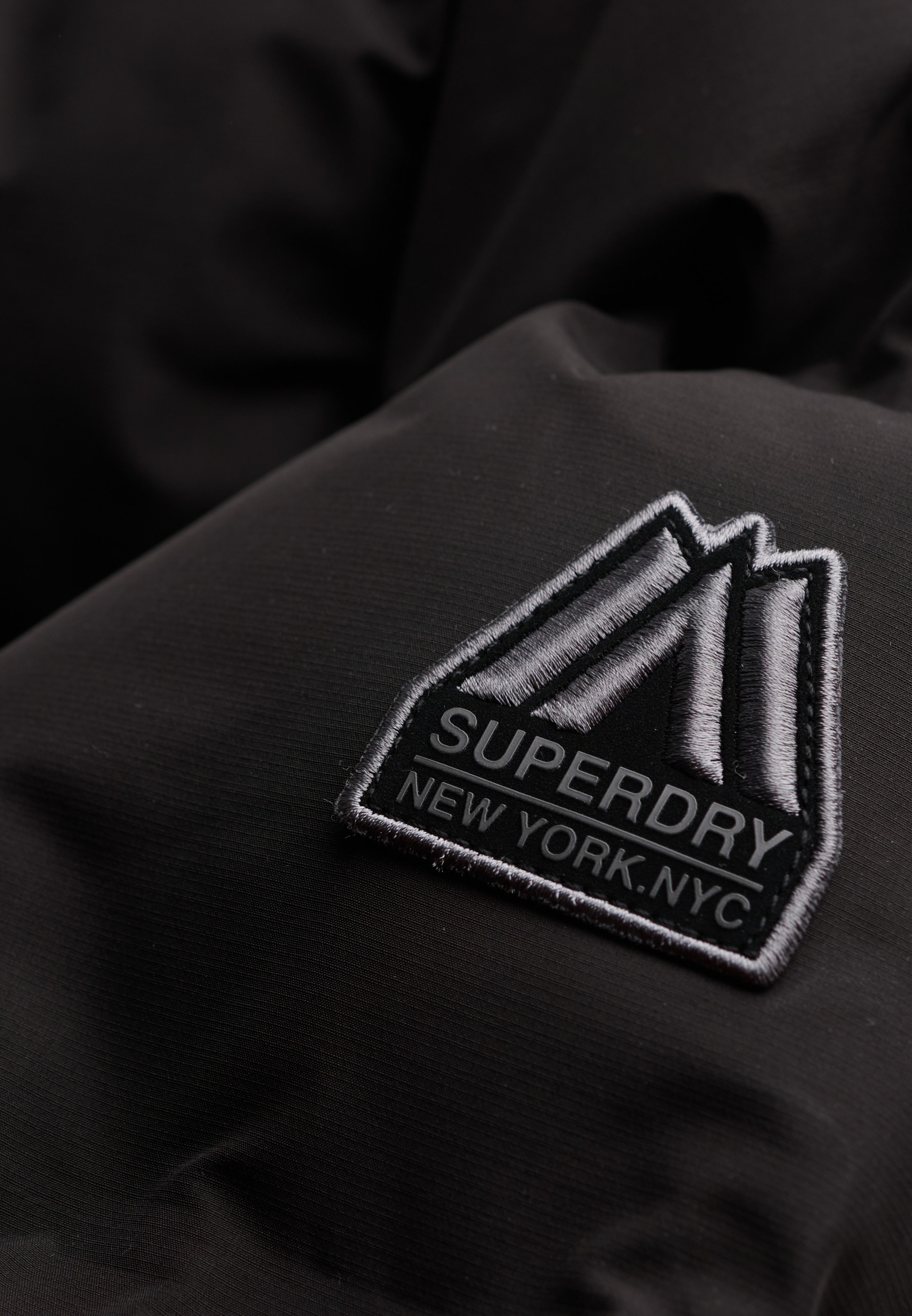 Superdry Veste matelassée »HOODED CITY PADDED JACKET« avec capuche fibre synthétique, coupe décontractée